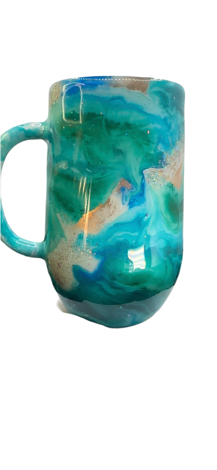 Turquoise tumbler with swirling blue, white, and gold accents, featuring a glossy finish, displayed on a white stand with black fabric.